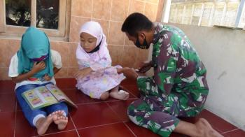 Tengah Istirahat, Satgas TMMD Bojonegoro Luangkan Waktu Bantu Anak Dusun Kramanan Belajar Membaca